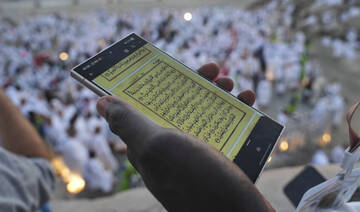 A Muslim pilgrim uses a mobile phone to read chapters from the holy Quran in Makkah, Saudi Arabia, Thursday, June 5, 2025. (AP)