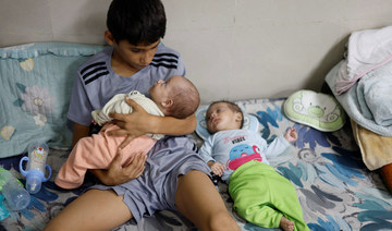Displaced Palestinian boy looks after his twin siblings as they take shelter at Nasser hospital in Khan Younis, Gaza Strip.